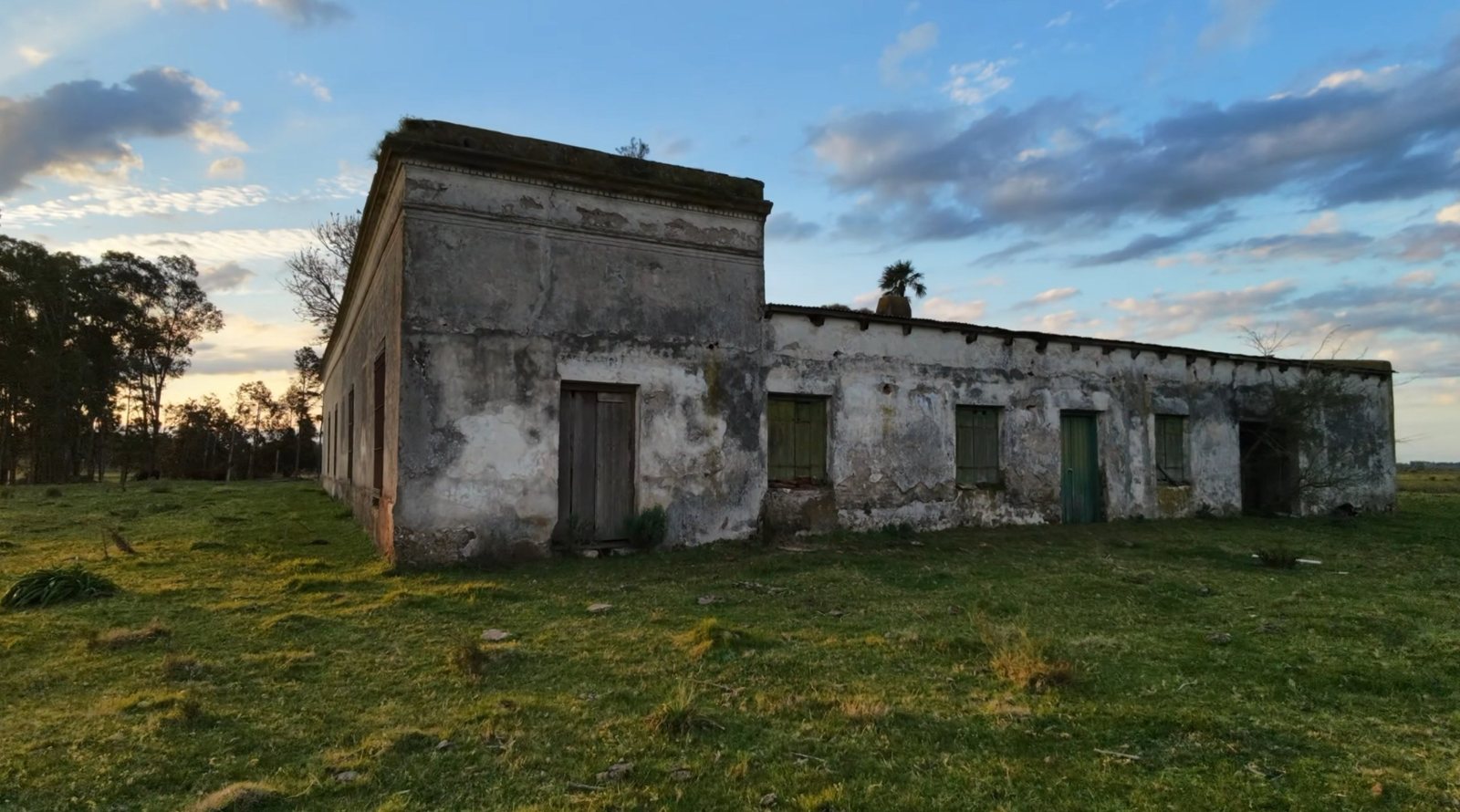 A Estancia Benítez ao entardecer, uma casa antiga de paredes descascadas no meio do campo